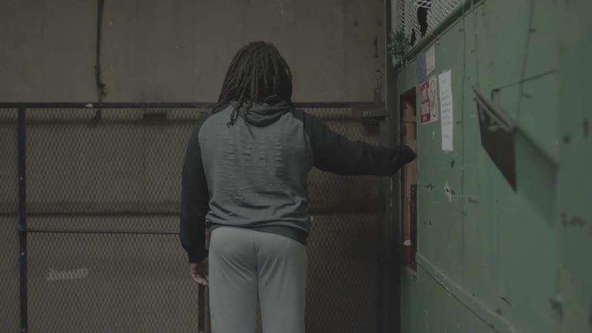 A man in dreadlocks is riding a freight elevator