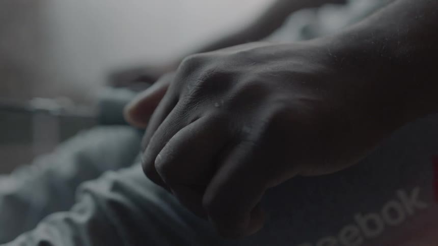 A close up view of a  person sitting in a room holding something in their hands