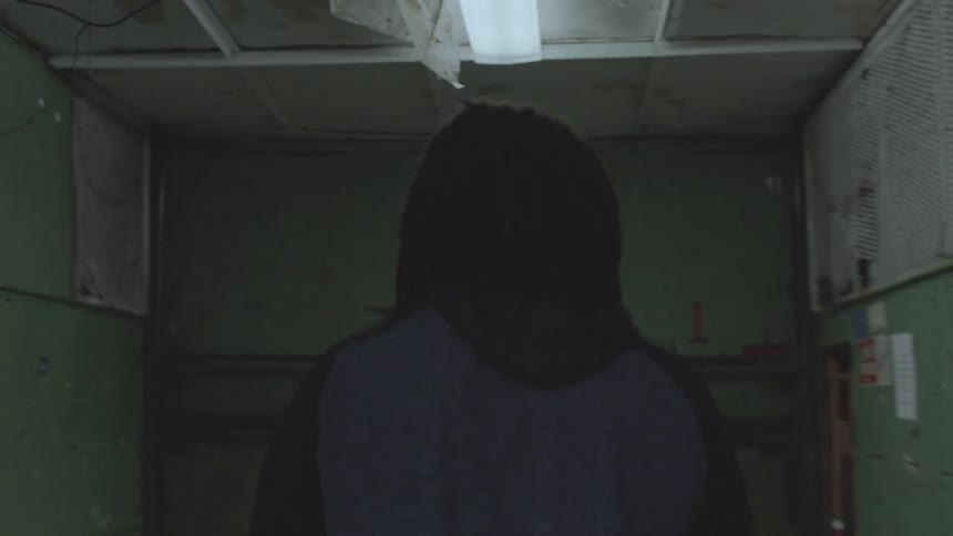 A man is walking into an service elevator in an urban building
