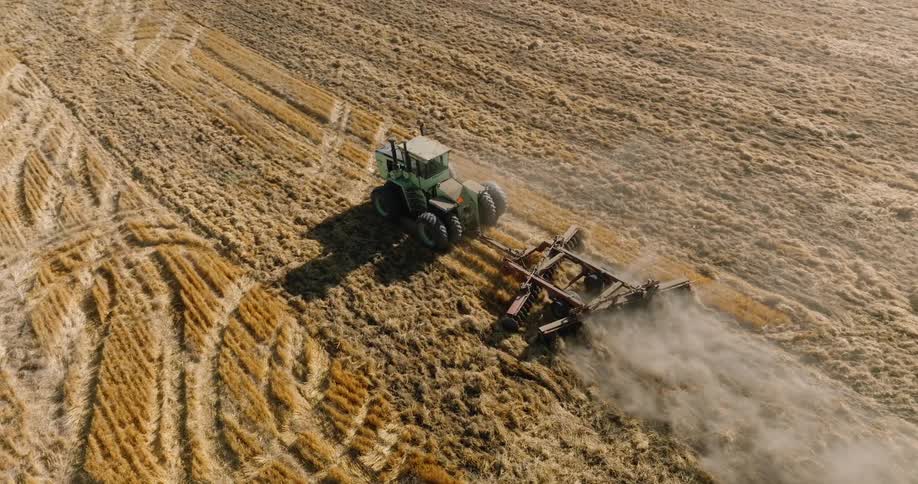 A tractor makes a crop circle on the field then drives off