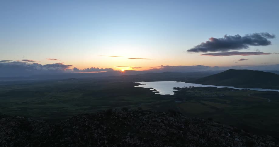 Aerial panorama of a mountainous landscape with the sun rising on the horizon