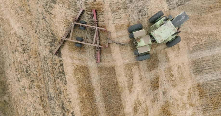 A tractor is making crop circles on the field
