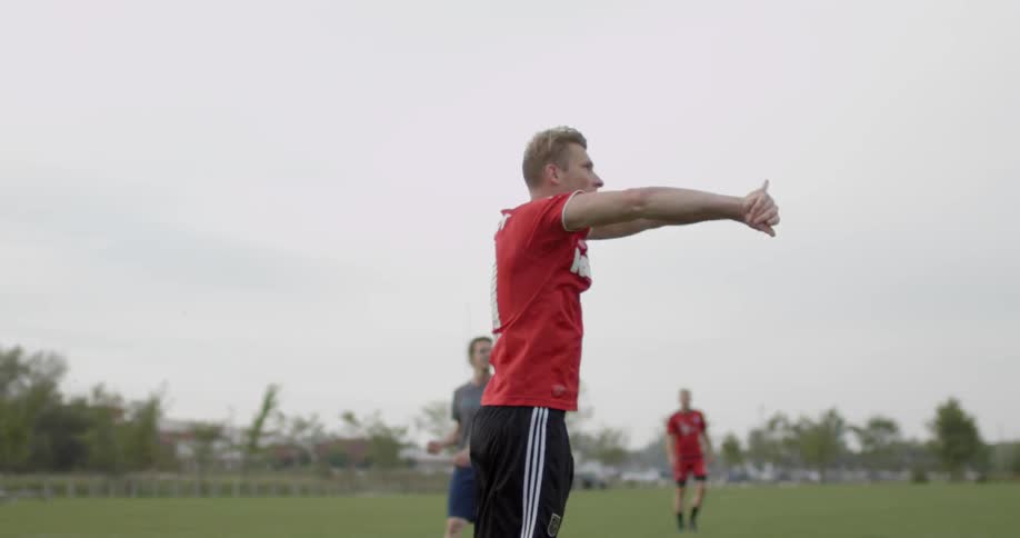 A man throwing a soccer ball outside on a field