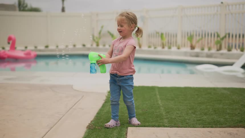 A clip of a kid plying with a toy gun beside the pool
