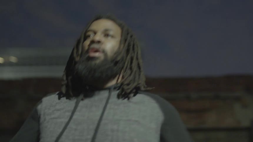 A man stretches his arms outside at night