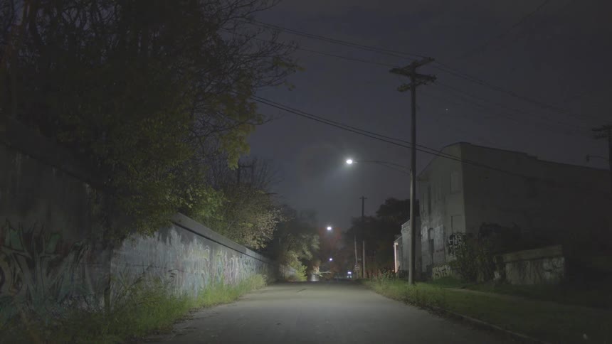Street lamps light a sidewalk at night