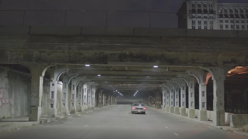 A car is driving through a wide open tunnel