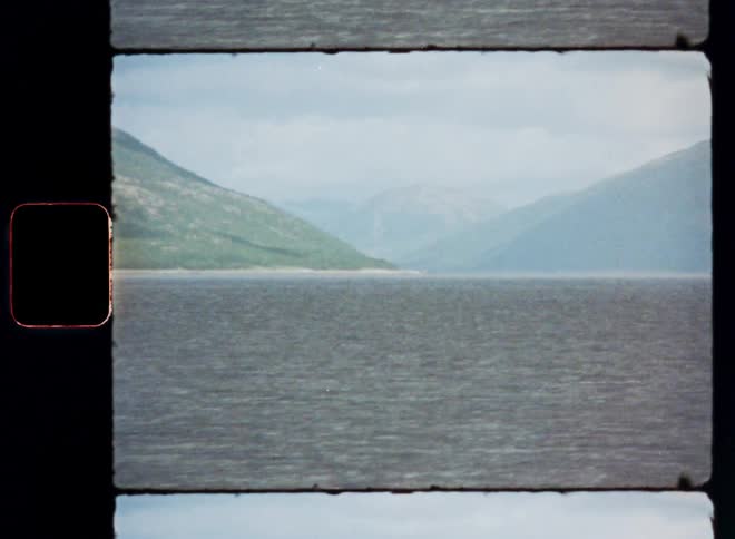 A large lake with a flat surface and in the background there are some distant mountains