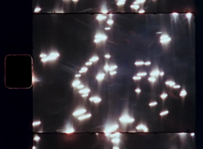 Several white lights passing to the right in a dark environment