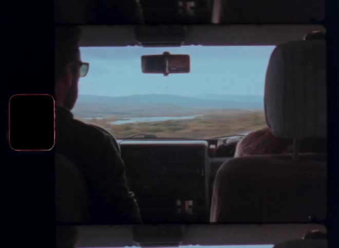 Inside view of a man and a woman sitting in the front seat while driving