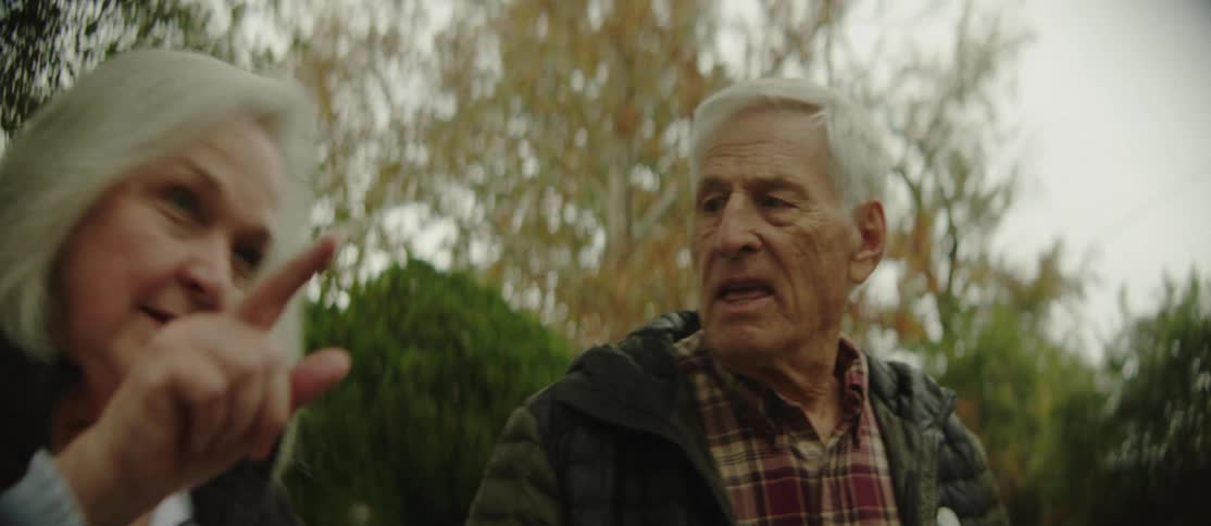 An older couple walks and talks outdoors