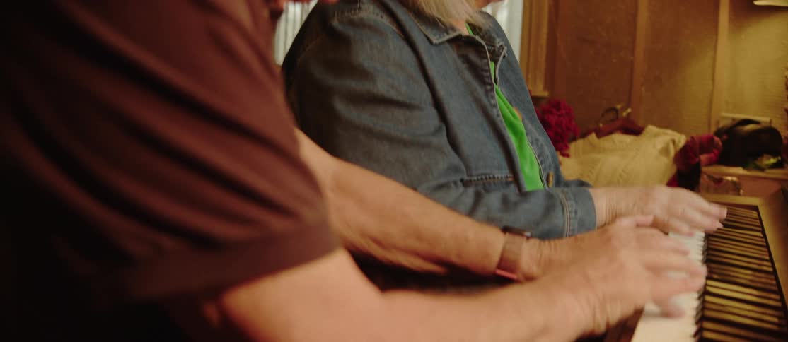A close up footage of an elderly couples playing a piano