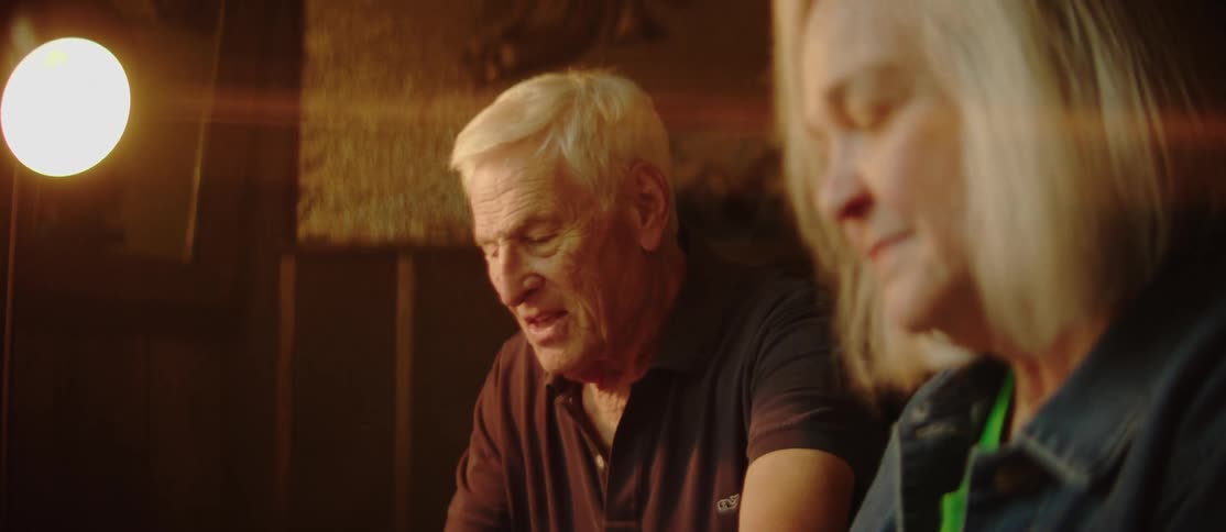 Elderly man and woman sitting side by side playing an electric piano together laughing and enjoying themselves