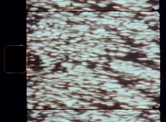 A body of water with sunlight reflecting on it creating a rippling pattern of light and shadow