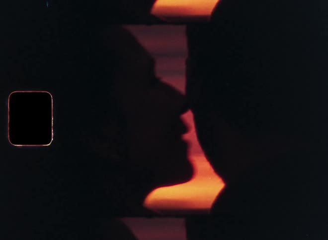 Silhouette of a woman kissing a man on the cheek