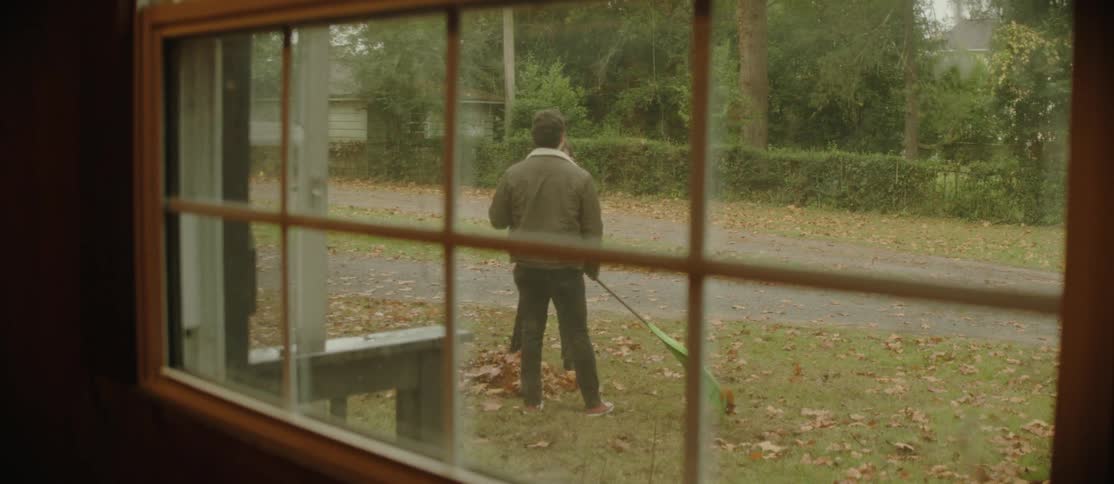 A young couple is raking leaves in the front yard