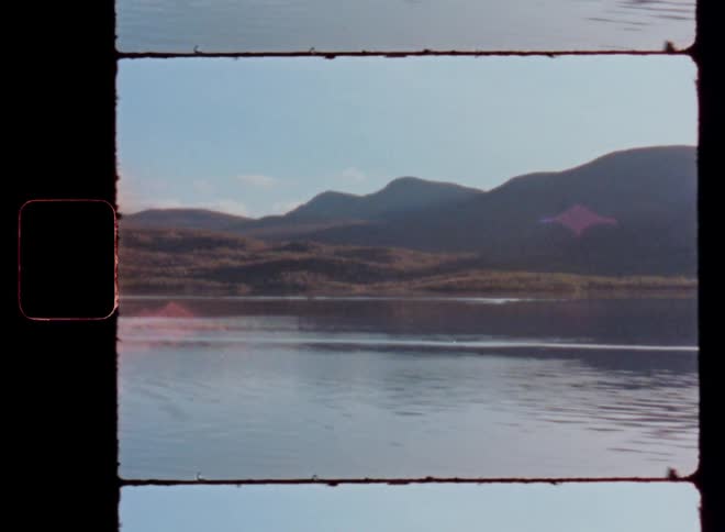 A calm lake with a mountain range in the background