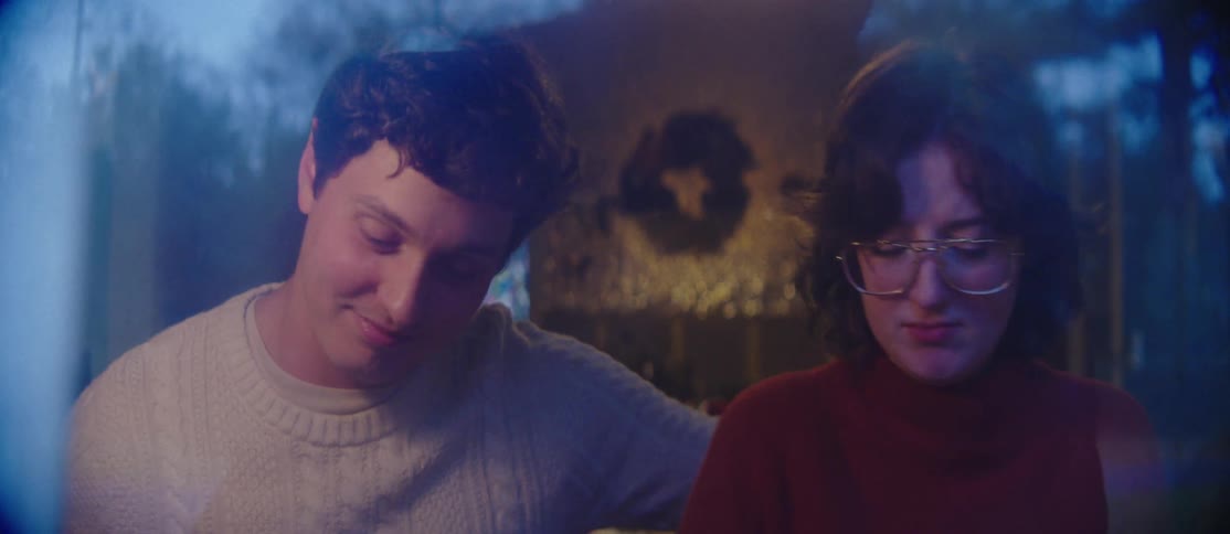 Cheerful couple sitting together side by side in an indoor setting