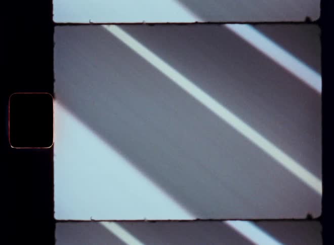 Closeup view of white lines on a road as seen from a moving vehicle
