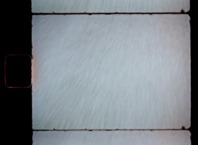 A closeup view of a road from a moving perspective captured on vintage film