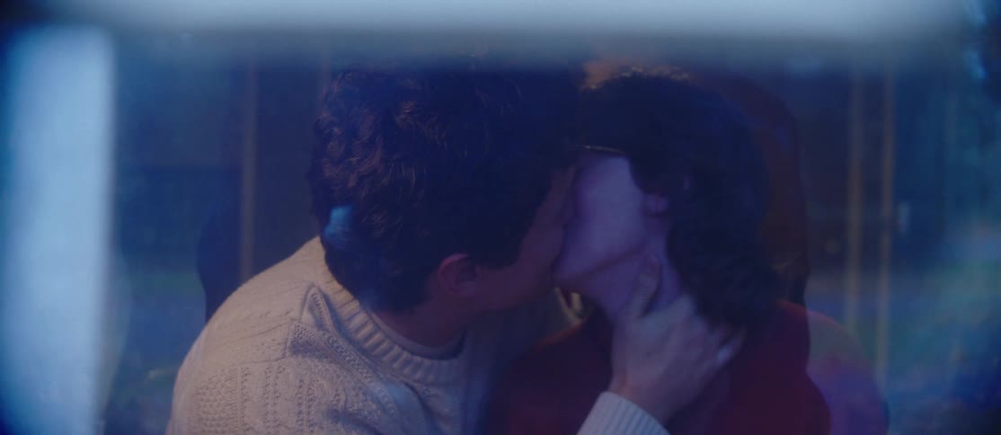A couple are kissing inside
