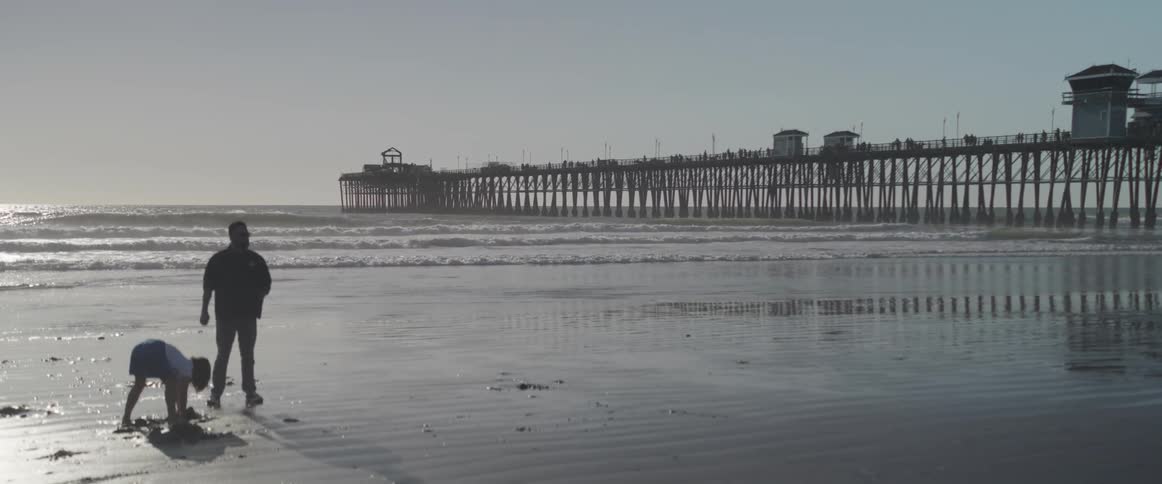 A child is digging in the sand on the beach