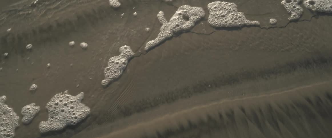 Sea water connecting with wet sand