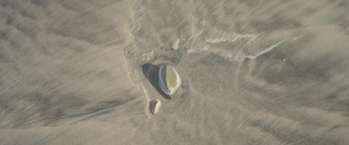 Two small stones on the beach sand