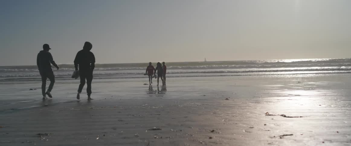 People running including children and adults on the beach sand