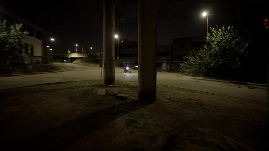 A person riding a motorcycle on a street at night