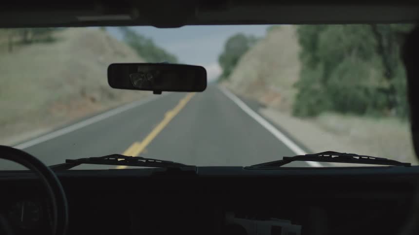 A vehicle drives down a rural road