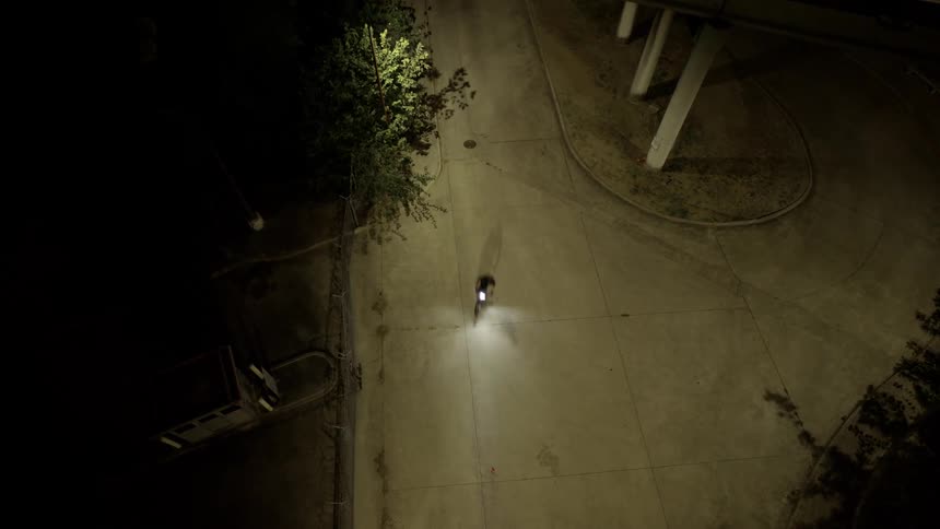 Overhead view of a person passing by a lonely highway at night
