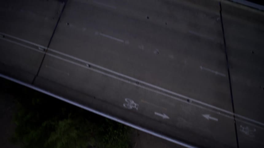 Person with a motorcycle passing under viaducts