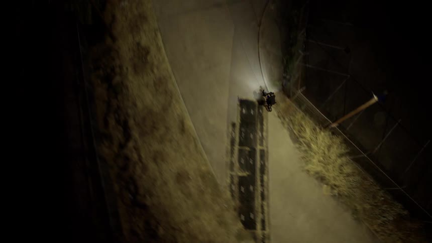 An aerial clip of a person riding a bike at night