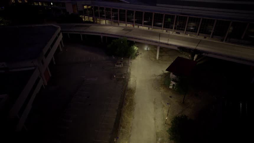 Aerial view of a bridge in front of a city that is lit up at night