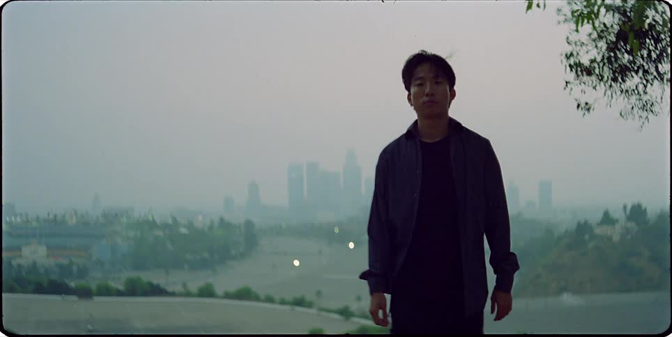 Film footage of a man walking on the outskirts of a city