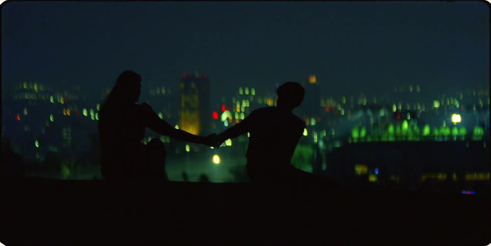A clip of a male and female sitting and holding hands