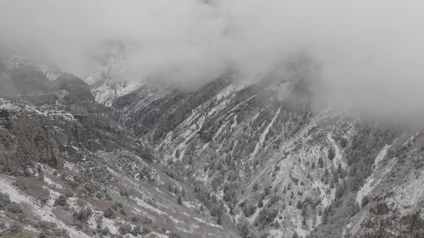 Aerial panorama of snowy mountain ranges on a foggy day