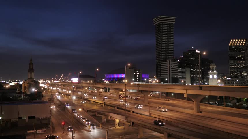 Busy city highway with buildings in the background at night