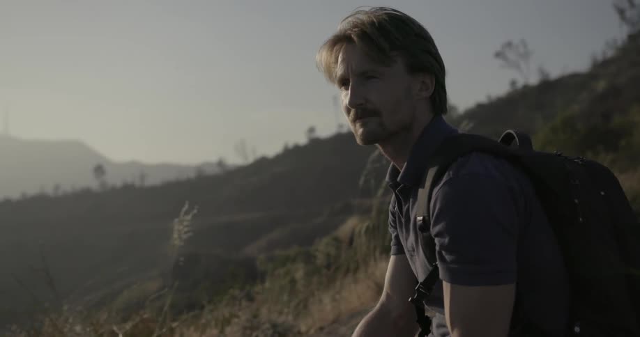 Man sits on a hillside looking at nature