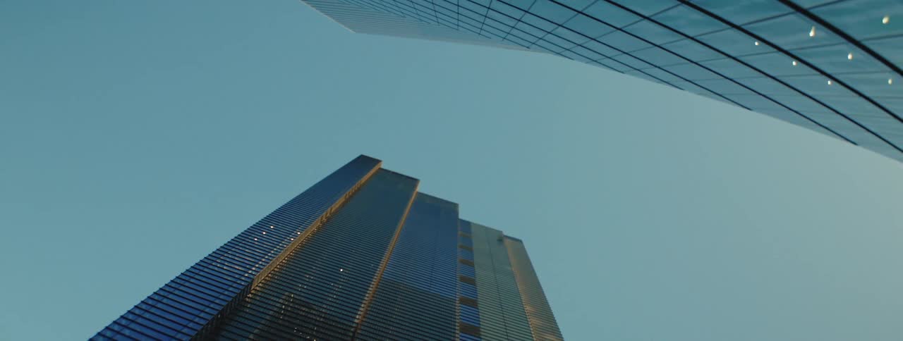 A low angle view of two tall modern skyscrapers against a clear blue sky