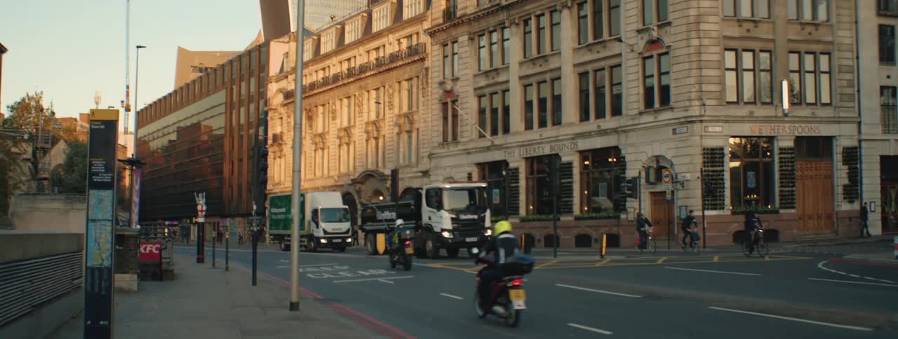 A bustling city street with a mix of historic and modern buildings including the iconic shard skyscraper