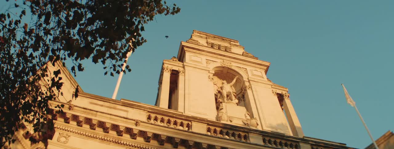 Upward view of a building with classical architecture against a blue sky