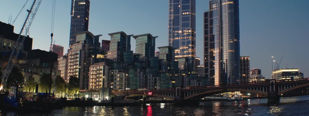 A view of the london skyline at dusk with the river thames flowing in the foreground