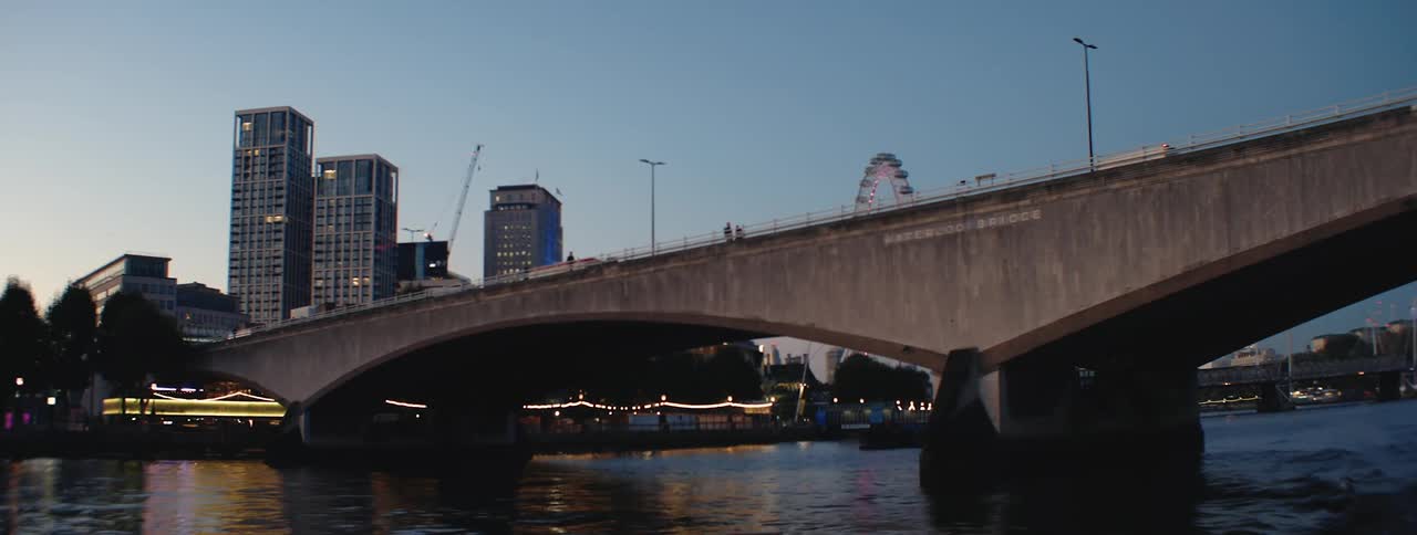 A view of the london skyline at dusk with the london eye ferris wheel and several tall buildings visible in the background