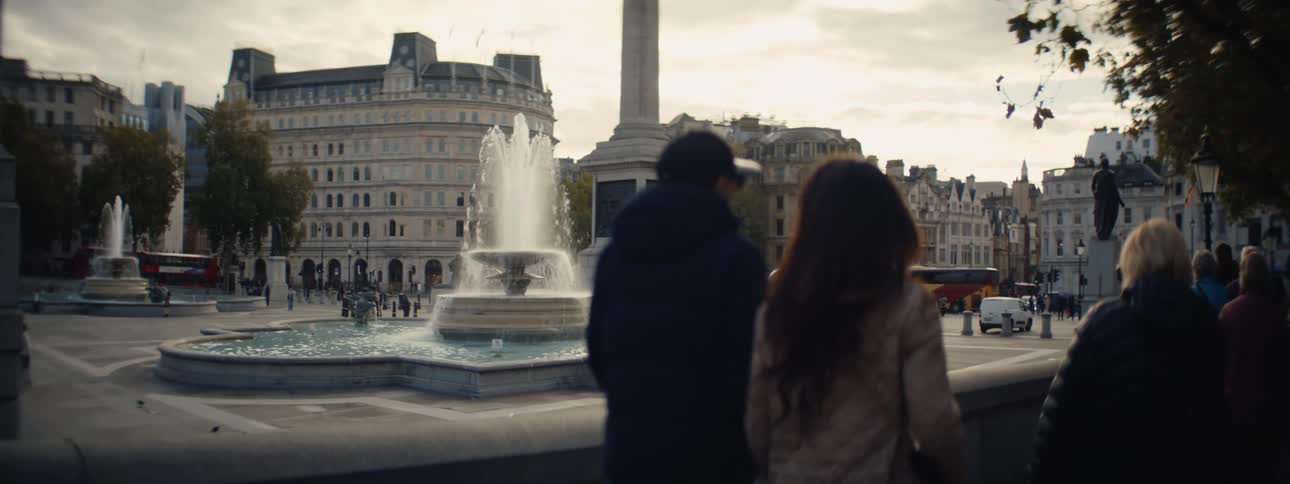 Tourists walk past a large fountain