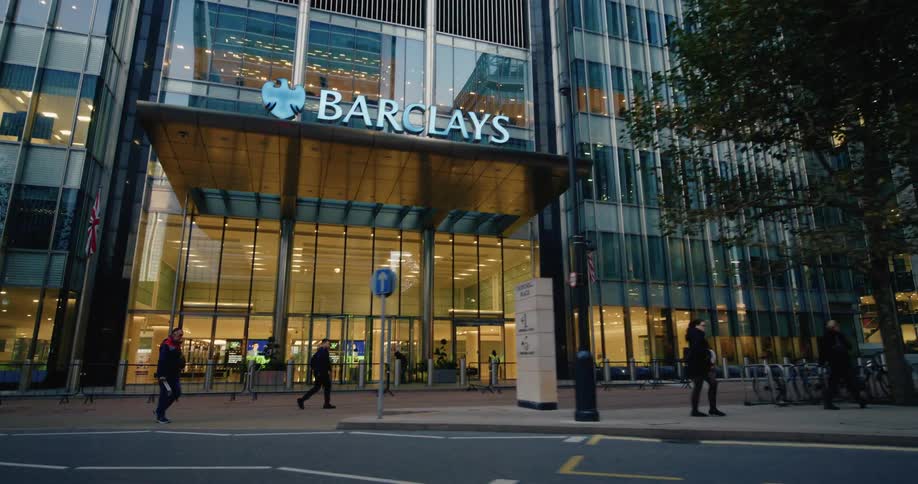 Pedestrians walking in front of a modern mirrored building