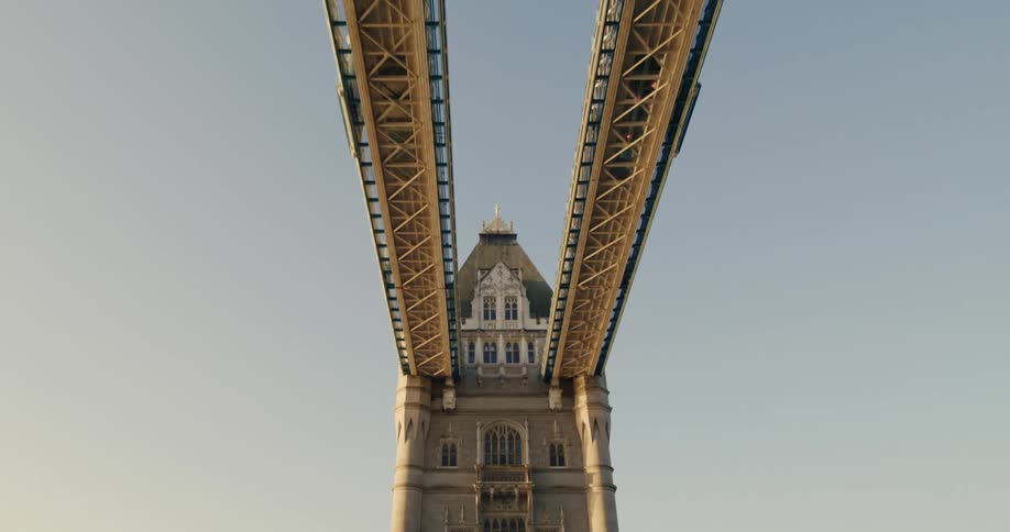 Classic arch of london bridge passing a red tourist bus