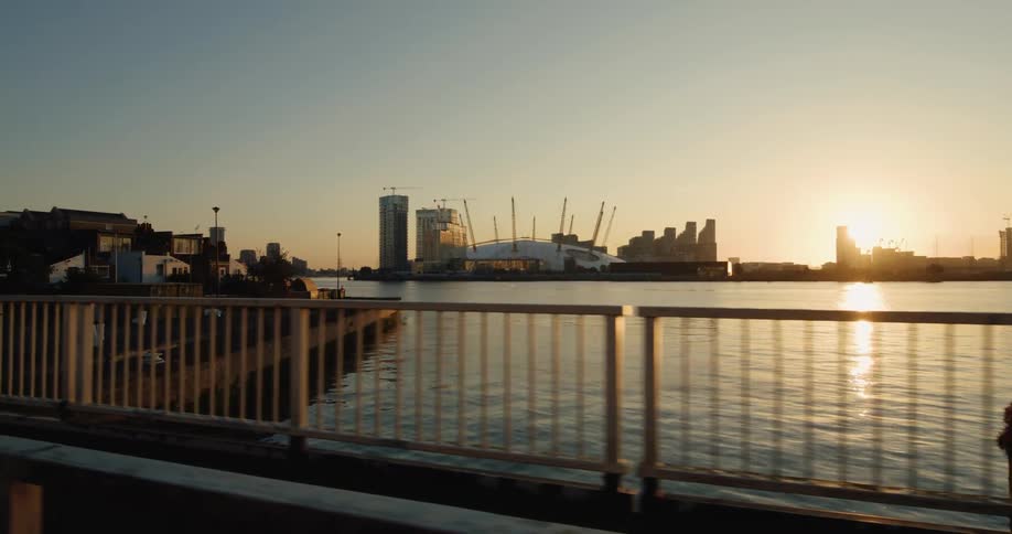 Moving view across a bridge over the sea and in the background a modern museum