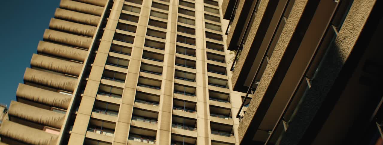 A tall imposing concrete buildings with a distinctive brutalist architectural style reaching towards the sky
